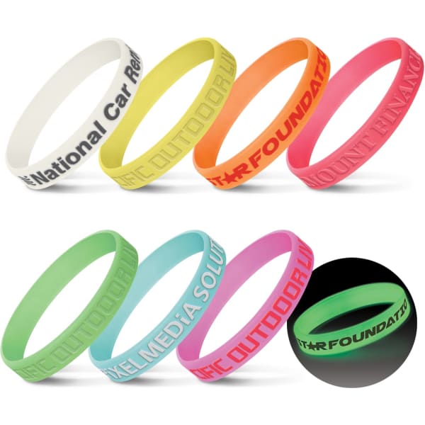 A collection of silicone wristbands in various colours, including white, yellow, orange, pink, green, and a glow-in-the-dark option.