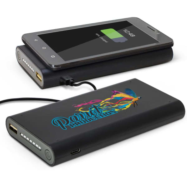 A power bank in black, featuring a colourful design, with a smartphone connected and charging on top.