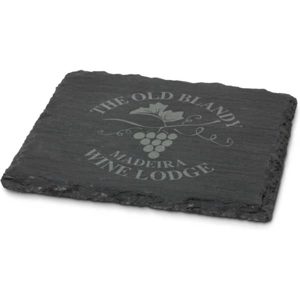 A single slate coaster in dark grey with a textured edge and an engraved design.