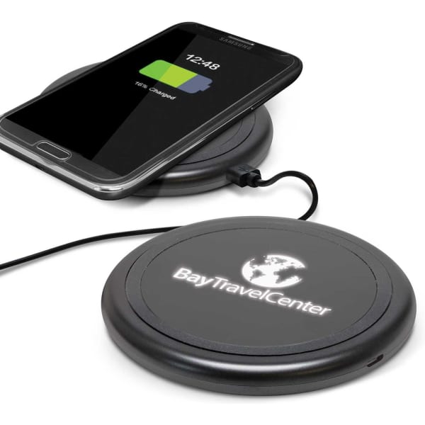 A wireless charger in black, with a smartphone placed on top, displaying a charging icon and battery level.