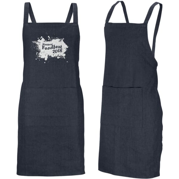 A denim bib apron in dark blue, featuring a front pocket and adjustable straps. Branding is visible on the front.