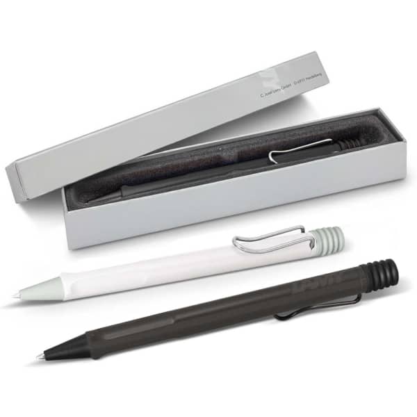 A set of Lamy Safari pens in white and dark green, presented in a grey box with a logo.