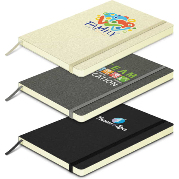 Three notebooks stacked together: a cream notebook with a logo, a grey notebook with text, and a black notebook with a logo.