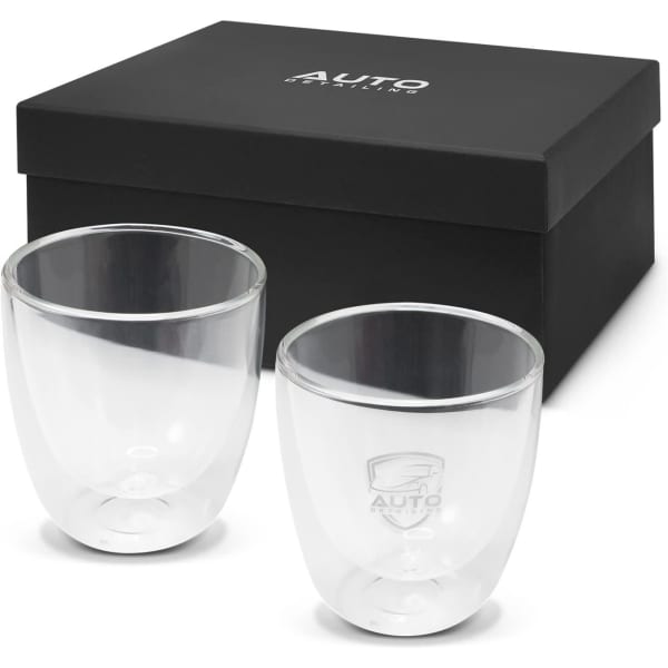 A set of two clear double wall glass cups in a black gift box, featuring a logo on each glass.
