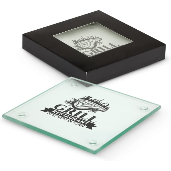 A square glass coaster, clear with a black base and branding, displayed in a black box.