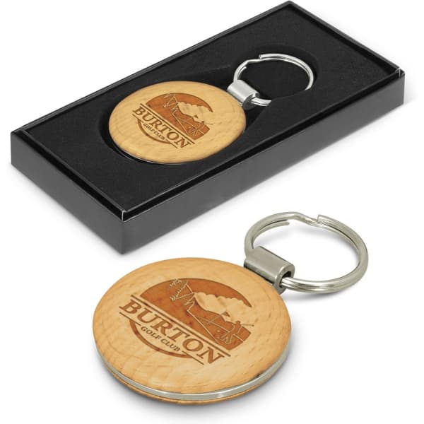 A round wooden key ring with a metal keychain, presented in a black gift box. Features a logo on the wooden surface.