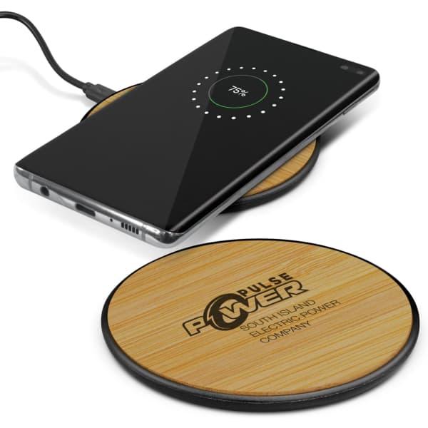 A bamboo wireless charger in a circular shape, with a smartphone placed on top, featuring a logo on the surface.