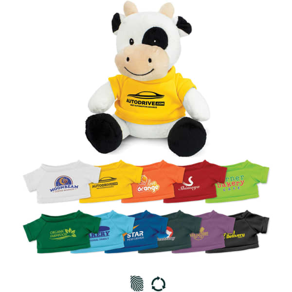 A plush toy cow wearing a yellow shirt, surrounded by various smaller shirts in different colours. The toy has a logo on it.