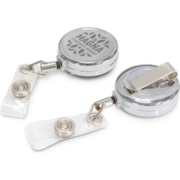 A silver retractable ID holder with a clip and clear strap, featuring a logo on the front.
