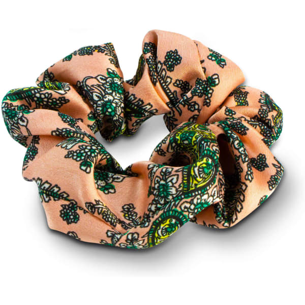 A fabric hair scrunchie in peach with green floral patterns, featuring a decorative design.