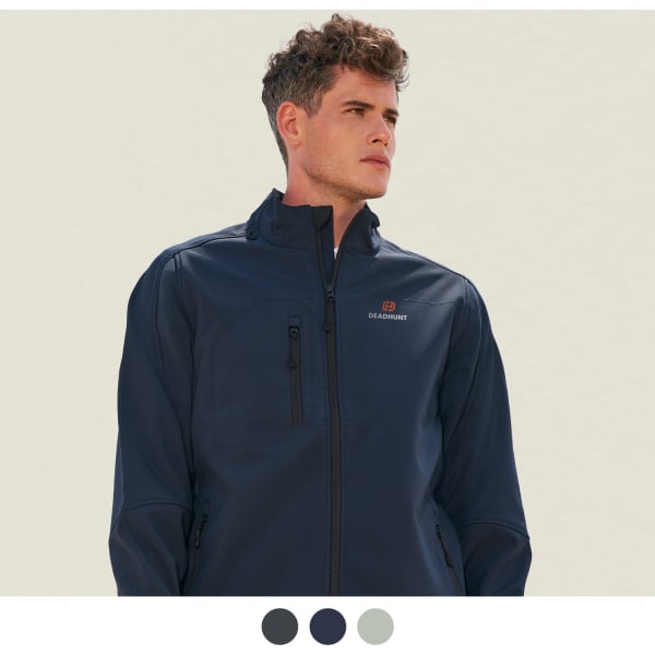 A man wearing a navy softshell jacket with three side pockets and a logo on the chest.