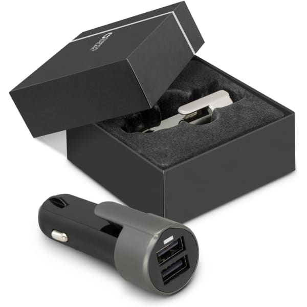 A black and grey USB car charger is displayed next to its box with a foam insert, featuring a logo.