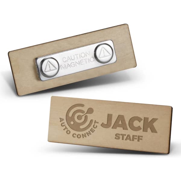 A wooden badge in light brown with a magnetic backing. Features a logo on one side and a caution symbol on the other.