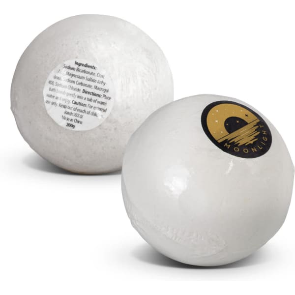 A white bath bomb with a round shape and a logo on one side, featuring a label with ingredients on the opposite side.