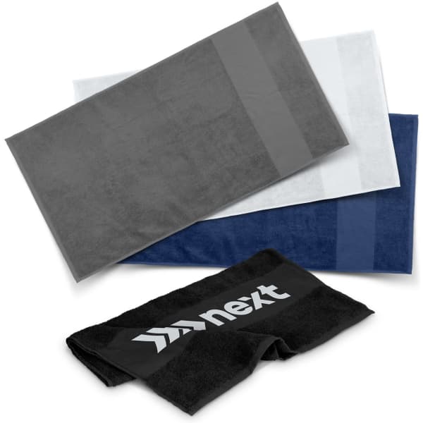 A stack of gym towels in grey, white, navy, and black with a logo on one towel.
