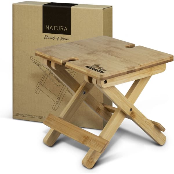 A bamboo folding wine table in a natural finish, alongside its packaging. Features a logo on the table.