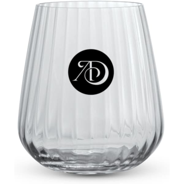 A clear stemless lowball glass with a ribbed design and a circular logo on the front.