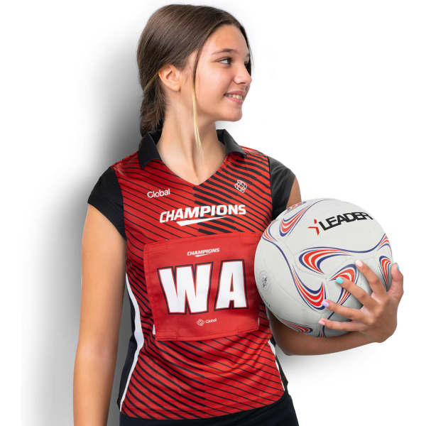 A red netball bib with a black collar and a logo, held by a person, alongside a netball.