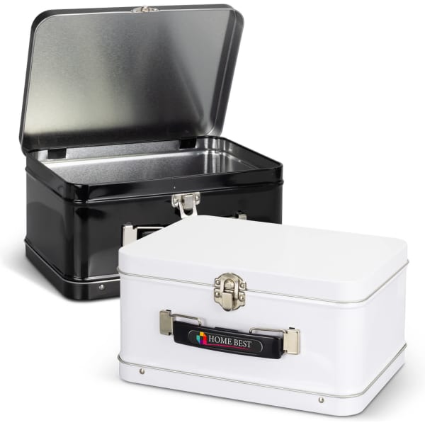 Two tin lunch boxes, one black and one white, with shiny interiors and metal latches, featuring a logo on the white box.