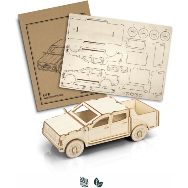 A wooden model of a UTE in a light natural finish, accompanied by a sheet of wooden parts for assembly.