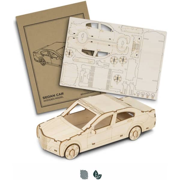 A wooden model of a sedan car in a natural wood finish, accompanied by assembly instructions.