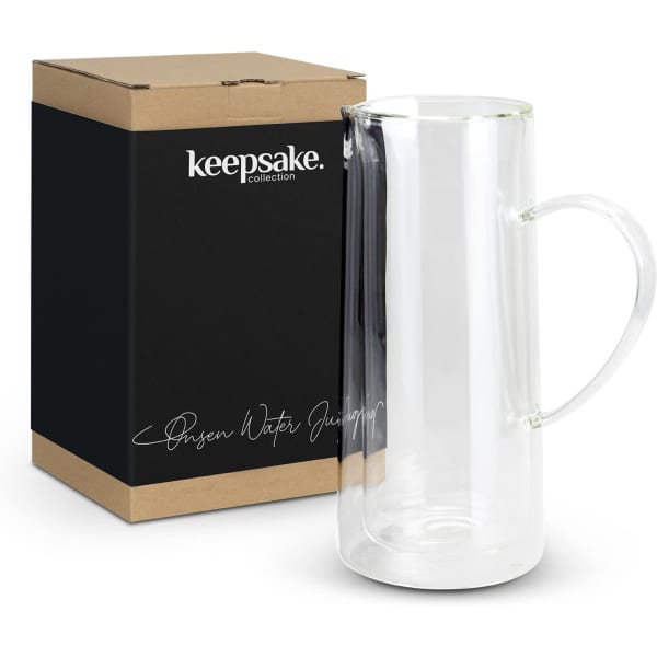A glass water jug with a handle, alongside its sleek black packaging featuring a logo.