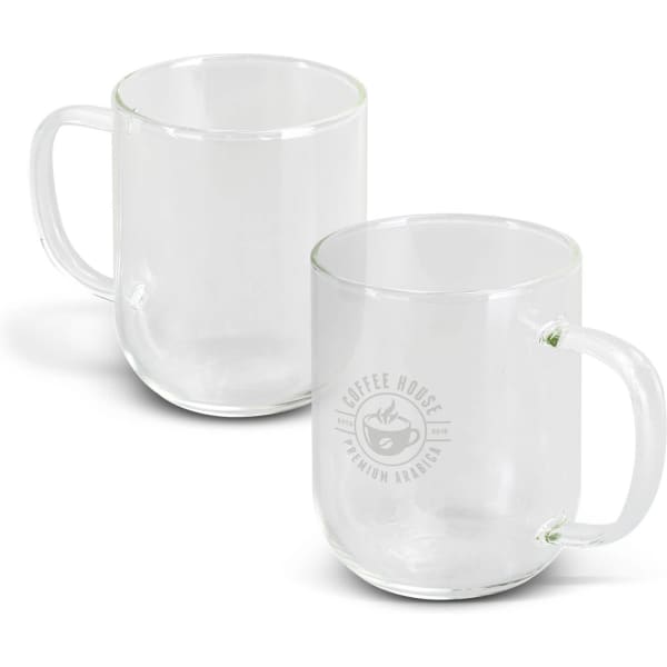 A glass mug in clear colour with a handle and a logo on one side. Two mugs are displayed.