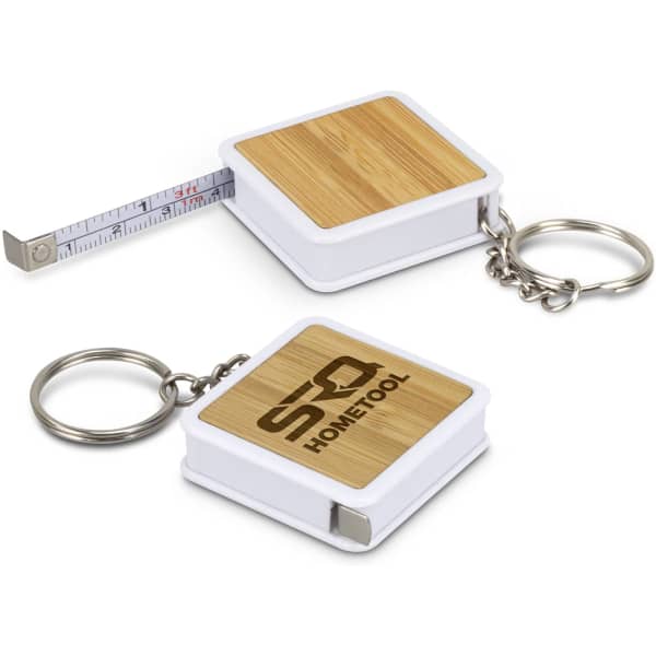 A bamboo tape measure key ring with a white casing and a silver key ring attachment. Features a measuring tape inside.