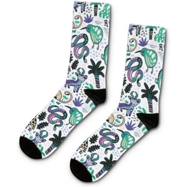 A pair of crew socks featuring a vibrant design with green, purple, and black motifs, including animals and plants.