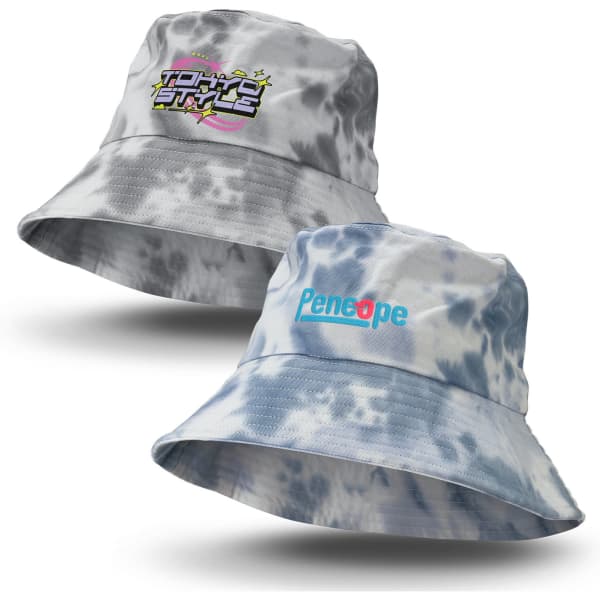 A grey and blue tie dye bucket hat featuring a logo on one side and text on the other.