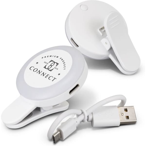 A white selfie light with a clip and USB charging cable, designed for mobile phones. It features a branded logo.