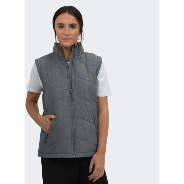 A grey women's puffer vest with a zip front and pockets, worn over a white t-shirt. The model stands against a plain background.