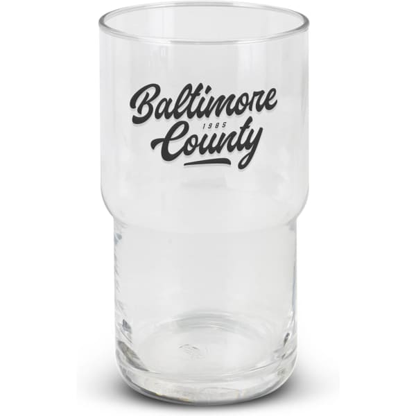 A clear stackable glass tumbler featuring a black logo. The glass has a cylindrical shape with a wider base.