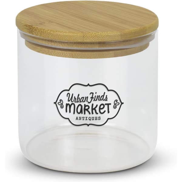A large round glass storage canister with a bamboo lid and a decorative logo on the front.