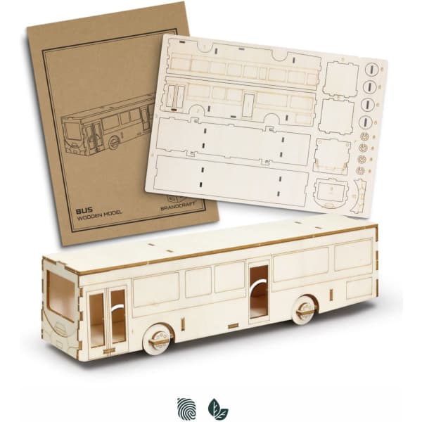 A wooden model bus in natural wood colour accompanied by assembly sheets featuring detailed cutouts.