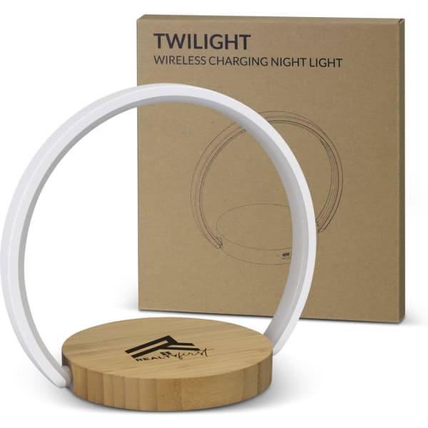A wireless charging night light with a wooden base and a white ring, next to a plain cardboard box featuring a logo.