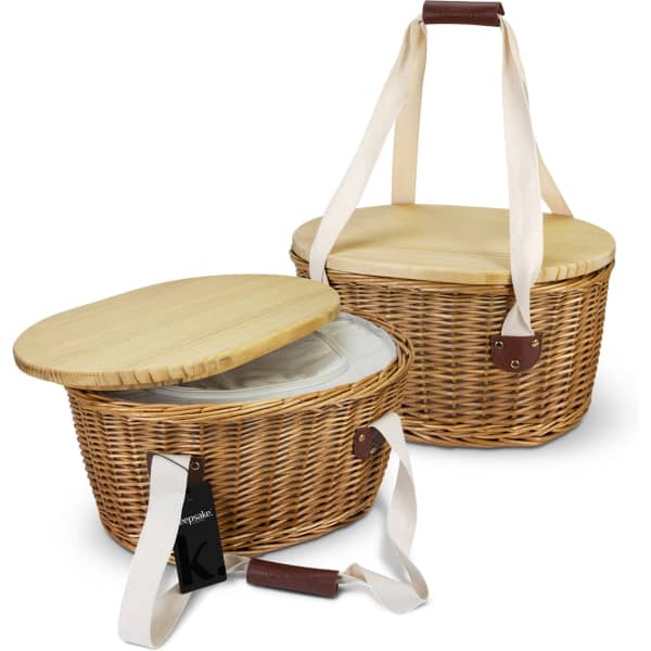 A woven wicker picnic cooler basket in natural tones, featuring a bamboo lid and cotton straps. It includes a lining.