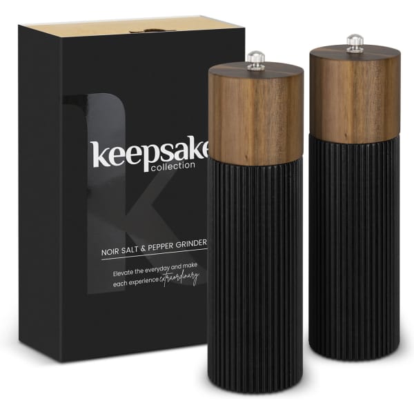 Two black salt and pepper grinders with wooden tops, packaged in a sleek black box featuring a logo.