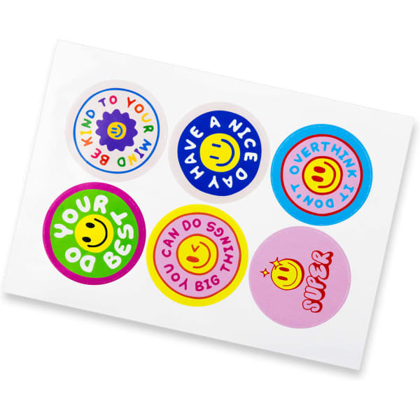 A sticker sheet featuring six circular stickers in various colours, each with cheerful designs and a smiley logo.