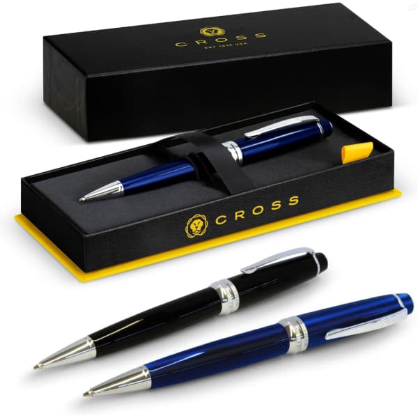 A blue and black Cross Bailey ballpoint pen set in a black box with a yellow interior and branding.