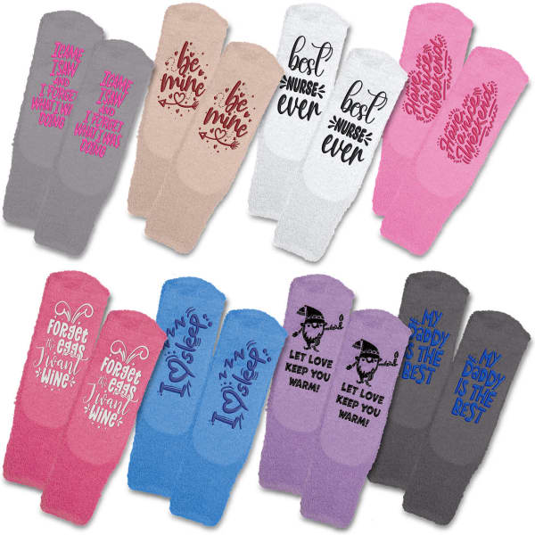 A variety of fluffy grip socks in pink, grey, and beige, featuring playful text designs and a logo on some pairs.