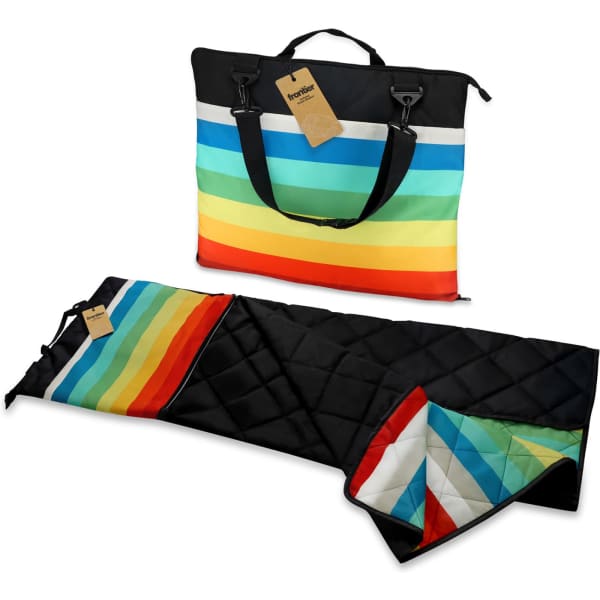 A picnic blanket in vibrant stripes of red, orange, yellow, green, and blue, packaged in a black carry bag with handles.