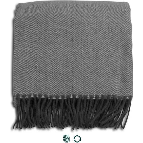 A grey herringbone throw blanket with fringed edges, neatly folded. It features a logo in one corner.