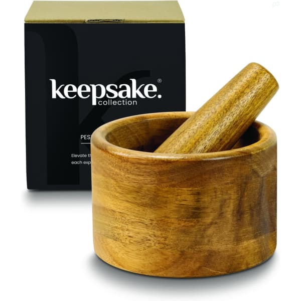 A wooden mortar and pestle set in a brown finish, displayed with a black box featuring branding.
