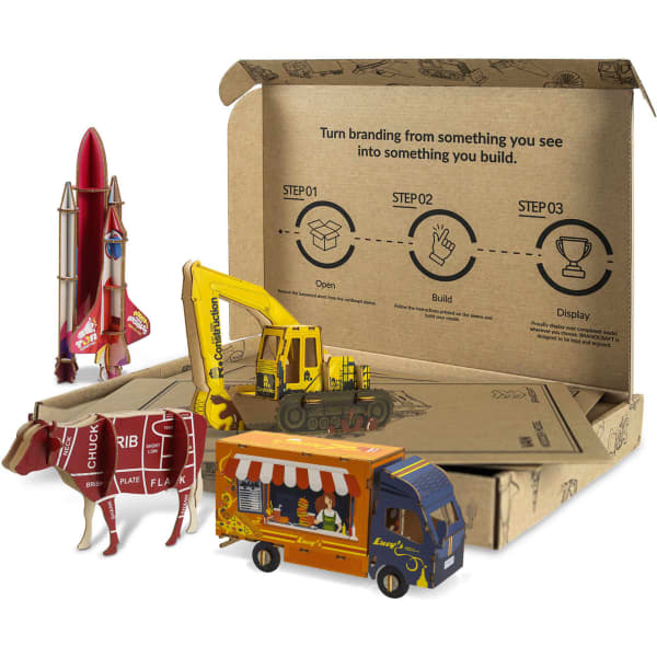 A cardboard box containing model toy vehicles and a rocket, showcasing various shapes and vibrant colours.