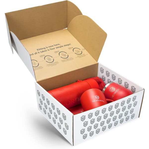 A red drink bottle and mug inside an open box with a branded interior design.