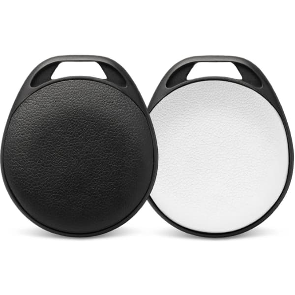 A pair of circular Bluetooth trackers in black and white, featuring textured surfaces and a carry handle.