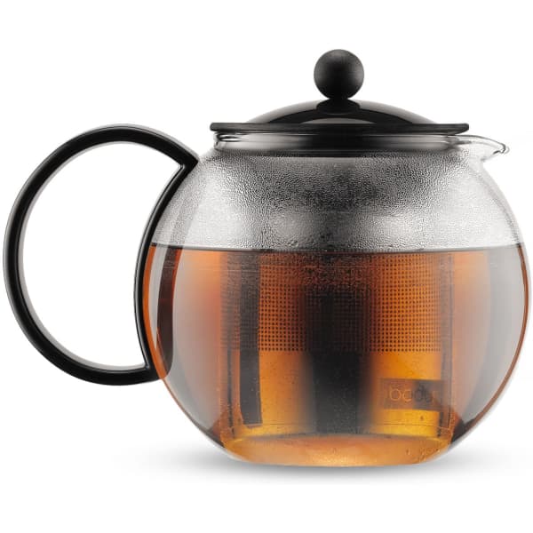A tea press with a black lid and handle, featuring a clear glass body filled with brewed tea.