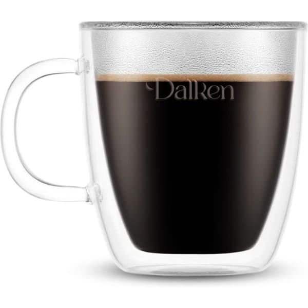 A double wall mug in clear glass filled with dark liquid, featuring a handle and a subtle branding logo.