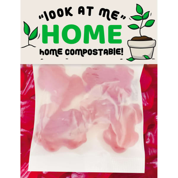 A packet containing pink gummy frog-shaped lollies, featuring a logo and text about being home compostable.